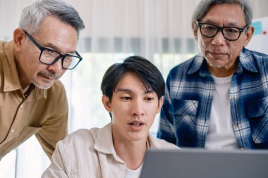 Bir acemi birliği kampı eğitimi sırasında akış çizelgelerini analiz eden bir grup Asyalı kıdemli yazılım geliştirici.