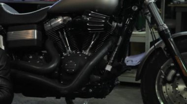 Erkek motorcu onun smarphone motosiklet yakınındaki yazarak. Motosiklet wopkshop, telefonda mesajlaşma sakallı adam. Cep telefonu yere otururken onun elinde tutan genç beyaz adam