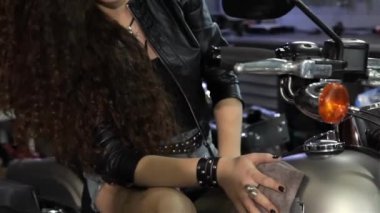 Çok kadın motorcu helikopter gaz tankı motosiklet atölyesinde silerek. Bir silme bez elinde tutan çekici beyaz kız kapatın. Genç seksi kadın, gaz tank temizleme