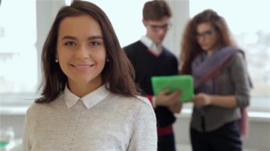 Beyaz adam ve kadın ofiste gülümseyen kız arkasında tablet bakarak. Esmer erkek ve kıvırcık kadın arka planda duran güzel esmer kadın. Esmer adam gözlük