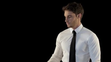 Zarif adam siyah arka plan karşı izole onun smartphone bakarak. Cep telefonu ile elini kaldırarak çekici bir beyaz adam. Beyaz gömlek ve siyah kravat koyarak giymiş genç tıraşsız adam