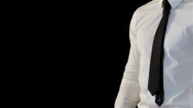 Siyah arka plan karşı izole ellerini ovuşturarak Caucaisan adam. Onun avuç içi bir başka boyunca hareketli bir genç adam. Adam beyaz gömlek ve siyah kravat iyi bir anlaşma el hareketi giymiş