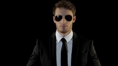 Çekici koruma onun palm tarafından yumruk tekme. Esmer adam dövüş için hazır olduğunu gösteren havacı güneş gözlüğü. Çekici beyaz adamın yumruğunu izole elini tutarak siyah paketindeki