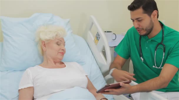 Médico Caucásico Barbudo Mostrando Algo Tableta Digital Una Paciente Femenina — Vídeo de stock