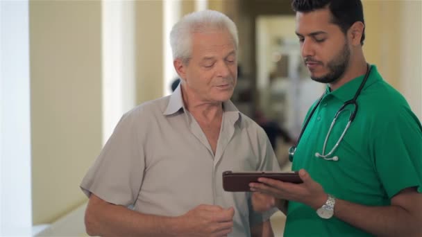 Morena Médico Caucásico Mostrando Algo Tableta Digital Para Hombre Mayor — Vídeos de Stock