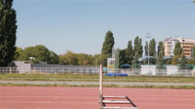 Genç erkek athlet Stadı nda engel üstünden atlayarak. Olimpiyat engel yan görünüm pist üzerinde. Beyaz sprinter Olimpiyat Eğitim