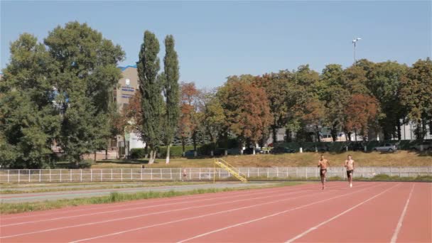 Két Férfi Egyensúlyérzék Fut Kifutón Stadionban Fiatal Sportolók Előtt Sprint — Stock videók