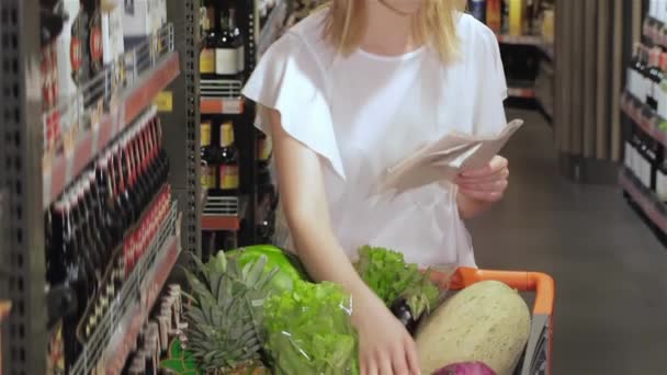 Młoda Dziewczyna Sprawdza Listę Produktów Kupienia Supermarkecie Ładna Dziewczyna Sortuje — Wideo stockowe