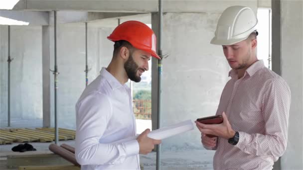 Zwei Junge Bauarbeiter Betrachten Das Digitale Tablet Bau Befindlichen Gebäude — Stockvideo