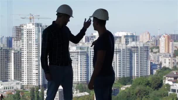 Два Будівельники Дивляться Ландшафт Високих Будівель Будівлі Будується Двоє Молодих — стокове відео