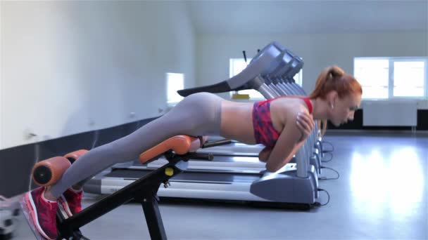 Junge Kaukasierin Trainiert Fitnessstudio Die Untere Rückenmuskulatur Attraktives Schlankes Mädchen — Stockvideo