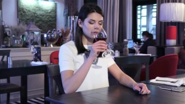 Restaurant sevgilisi için bekleyen genç ve güzel kadın. Café'de seyir çevrede çekici esmer kız. Şarap içme arıyorsunuz uzun saçlı kadın üzgün