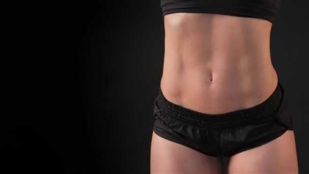 关闭的完美女性的肌肉肚子孤立在黑色背景上 性感健身女人把自己的身体两侧 有吸引力的白种女人展示她受过训练的肚子 — 图库视频影像