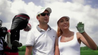 Çekici genç kadın golf sahasında elini tarafından işaret kapatın. Beyaz şapka ve güneş gözlüğü adamın yanında duran genç dişi golfçü. Oldukça Kafkas kadın elini önünde kaldırma