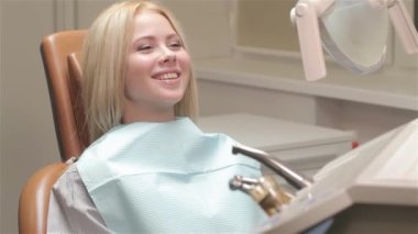 Güzel bir kadın dişçi koltuğu parmağını gösterilmesini. Diş hekimi sandalyede gülümseyen güzel kadın sarışın. Genç kadın alıcı diş muayenesi gülümseyen