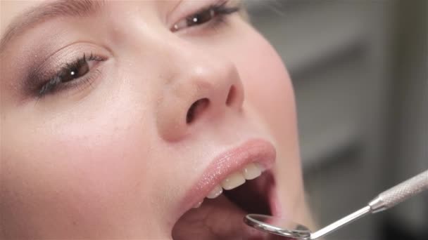 患者の唇にデンタル ミラーを置く歯科医のクローズ アップ 歯科検診後かなり金髪 Smilling 患者の歯を調べるデンタル ミラーを使って歯科スペシャ リスト — ストック動画
