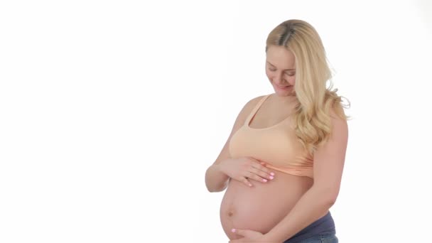 怀孕的金发女郎在工作室抚摸她的肚子 漂亮的孕妇高兴她的怀孕 微笑的孕妇孤立在白色背景 — 图库视频影像