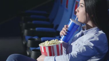 Asyalı kız profilde bir sinema soda içme. Arkadaşlar bir film izlerken sinemada. Sinema, eğlence ve insanlar kavramı - tiyatro film izlerken mutlu arkadaşlar. Çift ve diğer insanlar yemek