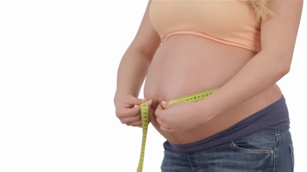 孕妇抚摸她的肚子后 它的测量 怀孕的女孩在测量她的肚子时 在摇摆 怀孕的金发女郎测量她的肚子 — 图库视频影像