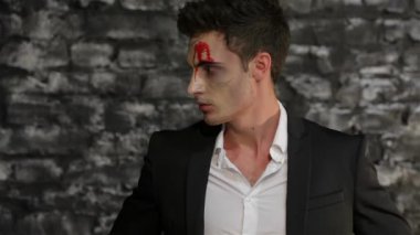 Seksi erkek vampir poz. Bir tuğla duvarın siyah arka plan üzerinde poz vampir görüntüadam. Cadılar Bayramı kavramları ve kostümleri