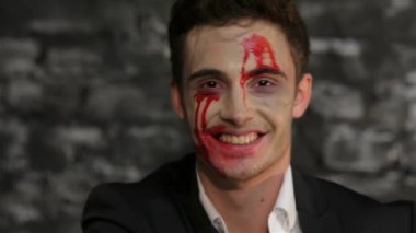 Vampir adam bir fotokopi alanı kartvizit gösterir. Bir tuğla duvarın siyah arka plan üzerinde poz vampir görüntüadam. Cadılar Bayramı kavramları ve kostümleri