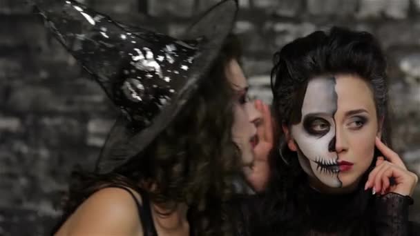 魔法师耳语骨架 女人在骨架和女巫的形象在砖墙的黑色背景 万圣节概念和服装 — 图库视频影像