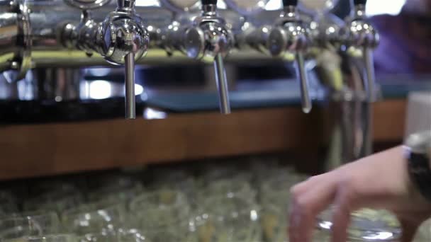 ビールでバーマンハンドのクローズアップ 干されたラガービールをタップ バーで手を満たすパイントの詳細 ビールタップで手を挙げて ラガーを注ぎます タップされたビール バーテンダー 新鮮な — ストック動画