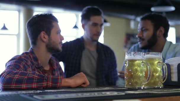 友谊和学士方概念 快乐的男性朋友喝啤酒在酒吧或酒馆 年轻男子们喝酒 聊天在咖啡馆里 老朋友见面 庆祝成功 — 图库视频影像