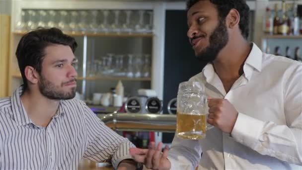 有的朋友一品脱 两名性格开朗的年轻男子 衬衫举杯与啤酒 一起坐在酒吧柜台 友谊和学士方概念 快乐的男性朋友 — 图库视频影像