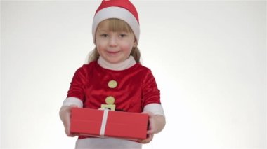 Bebek kız, çocuk, Noel Baba şapkalı çocuk stüdyoda poz veriyor. Beyaz bir arka planda izole edilmiş. Teklif, hediye, saate bakmak, kopyalama alanını gösterir, fotokopiciye bakar, şşşş yapar, oyuncak ayıya sarılır.