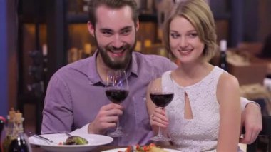 restoranda şarap bardakları ile nişanlı çift resmi. Bir restoranda Sevgililer Günü'nü kutluyorum. Bir kafede oturup kahve ve çay içen genç bir çift. İki kişilik bir gala yemeğine hayran kaldı.