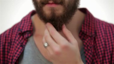 Mükemmel sakalına dokunan adamın daha yakın portresi. Yaşam tarzı kavramı: sakallı genç bir adam. Hipster tarzı. Beyaz arka plan üzerinde.