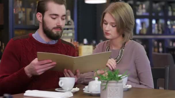 情侣选择菜单 在餐厅庆祝情人节 年轻夫妇坐在咖啡馆里喝咖啡和茶 为两人准备一顿晚宴 餐厅的浪漫晚餐 — 图库视频影像
