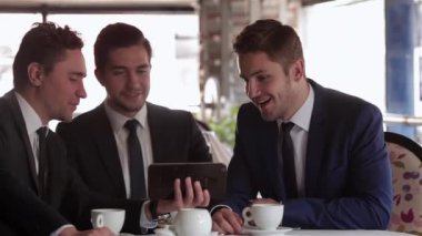 Restoranda, kafede, kafede iş yemeği. Rahat giyimli genç işadamı bir kafe, restoran, kahve dükkanı bir masada oturur.