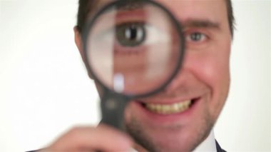 Genç işadamı beyaza izole edilmiş büyüteçten bakıyor. İş duyguları. İş adamları farklı durumdalar ve duygularını ifade ediyorlar. İnsani duygu yüz ifadesi