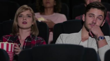 Çift ve diğer insanlar, muhtemelen arkadaşlar, sinemada film izliyorlar. Hüzünlü bir film gibi görünüyor. Sinema, eğlence ve insan kavramı - mutlu arkadaşlar tiyatroda film izlerken. Çift ve diğer