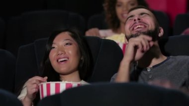 Sinemada film izleyen bir çift. Sinema, eğlence ve insan kavramı - mutlu arkadaşlar tiyatroda film izlerken. Çift ve diğer insanlar patlamış mısır yeme ve soda içerken film izlerken