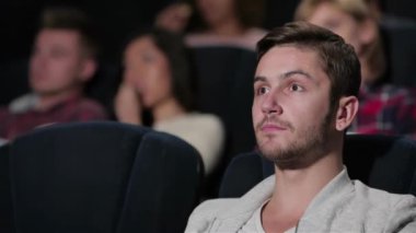 Bir fan filmi erkek bir film hikayesi izliyor. Sinema, eğlence ve insan kavramı - mutlu arkadaşlar tiyatroda film izlerken. Çift ve diğer insanlar izlerken patlamış mısır yeme ve soda içme