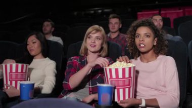 Çok katlı sinemada oturan, film izleyen, patlamış mısır yiyen bir grup genç. Sinema, eğlence ve insan kavramı - mutlu arkadaşlar tiyatroda film izlerken. Çift ve diğer kişiler