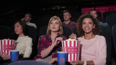 Gençler sinemada yakından bir film izliyorlar. Sinema, eğlence ve insanların konsepti. Tiyatroda film izleyen mutlu arkadaşlar. Çift ve diğer insanlar patlamış mısır yiyip soda içiyorlar.