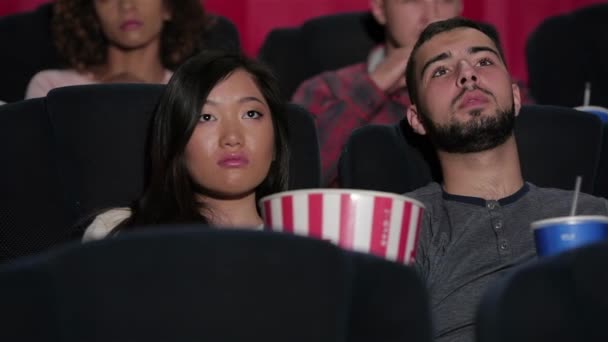 电影院里一对幸福的夫妇 欢快的年轻夫妇在电影院看电影 娱乐和人的概念 快乐的朋友看电影在剧院 夫妇和别人吃 — 图库视频影像