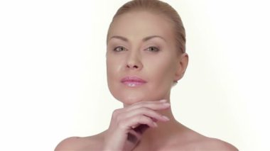 Beyaz arka planda güzel bir kadın portresi. Beyaz arka planda izole edilmiş kafkas kadın modeli. Mükemmel taze cilt. Saf güzellik modeli kadın kameraya bakıyor. Yüzüne dokunan güzel kız.