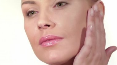 Beyaz arka planda güzel bir kadın portresi. Beyaz arka planda izole edilmiş kafkas kadın modeli. Mükemmel taze cilt. Saf güzellik modeli kadın kameraya bakıyor. Yüzüne dokunan güzel kız.