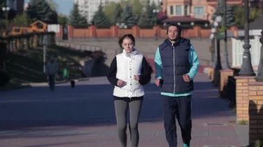 Kentsel koşu, spor, fitness ve insanlar hakkında kavram. Kentsel sporlar - güzel bir sonbahar sabahı şehirde fitness için koşu çift. Fit fitness egzersiz insanlar, sağlıklı koşucular çalışan.