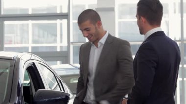 Araç edilmesidir. Yeni araba araç satıcısı gösteren genç adam. Otomatik iş, araba Satılık, teknoloji ve insan kavramı - auto göstermek ya da salon araba satıcısı ile mutlu erkek. Bir satıcı bir motor ile genç adam