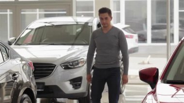 Adam maket araba seçer. Otomatik iş, araba Satılık, teknoloji ve insan kavramı - auto göstermek ya da salon araba satıcısı ile mutlu erkek. Bir satıcı motor gösterisi ile genç adam.