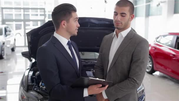 Junger Mann Mit Einem Verkäufer Auf Einer Motorshow Auto Geschäft — Stockvideo