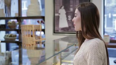 Çekici kız taze pişmiş ekmek satın aldı. Genç çekici kız, kadın kahve dükkanı veya fırın taze ekmek, hamur işleri, kek, kek, makarna satın alır. Bir alıcı bir cam kasa altında duran