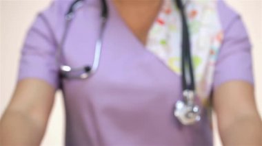 Hemşire ya da doktor ilaç ve elma gösteriyor. Şırınga, hap, fanendoskop, röntgen, pano, tıbbi maske, elma, şeker, yumuşak oyuncaklar ile beyaz bir tıbbi elbise bir Asya hemşire veya doktor kadın