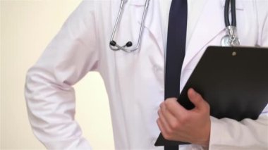 Panosu ile gülümseyen doktor. Şırınga, hap, fanendoskop, röntgen, pano, tıbbi maske, elma, şeker, çocuklar için yumuşak oyuncaklar, poz ile beyaz bir tıbbi elbise li beyaz bir hemşire veya doktor erkek